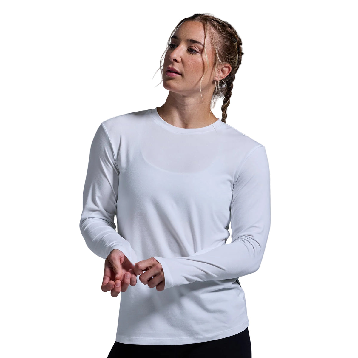 Woman wearing a white long-sleeve shirt against a plain background
