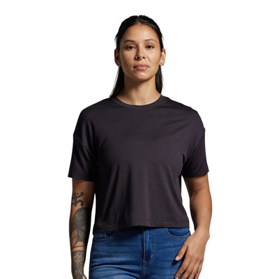 Person wearing a black t-shirt and blue jeans against a gray background