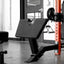 Gym equipment including a weight bench and weight plates in a gym setting.
