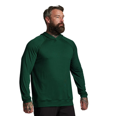 Man wearing a green hoodie against a gray background