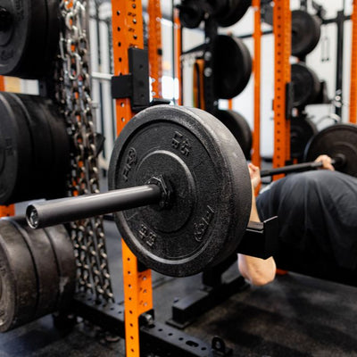Person performing a bench press with weights in a gym setting