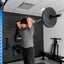 Person lifting a barbell in a gym setting