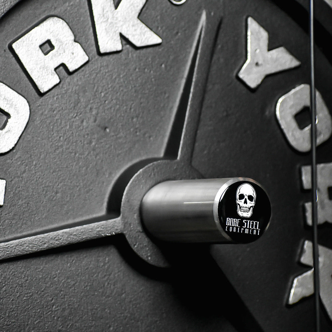 Close-up of a York barbell with a skull and crossbones sticker.