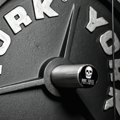 Close-up of a York barbell with a skull and crossbones sticker.