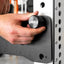 Hand adjusting a PRX mag pin on a white rack in a gym setting