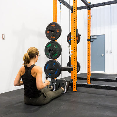 Woman performing a seated row using Ripcord Low Pulley and optional Foot Plate.