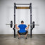 Man back squatting using Build Limitless Spotter Arms on Wall-Mount Rack