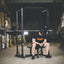 Athlete sitting on the Flat Utility Bench in front of the full cage